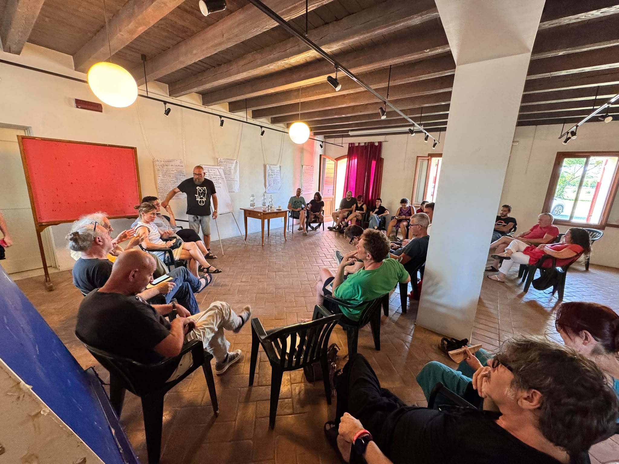 Il cerchio della discussione — flipchart alle spalle del facilitatore con gli appunti dei tre temi