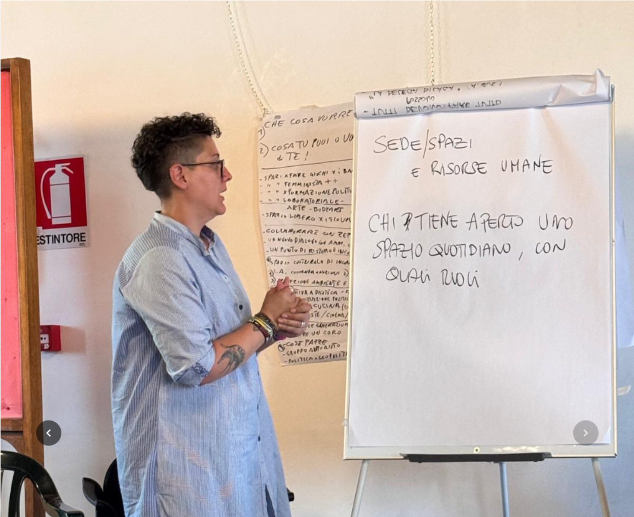 Valentina B. modera davanti al flip chart «Sede/Spazi e Risorse Umane — chi tiene aperto uno spazio quotidiano, con quali ruoli»