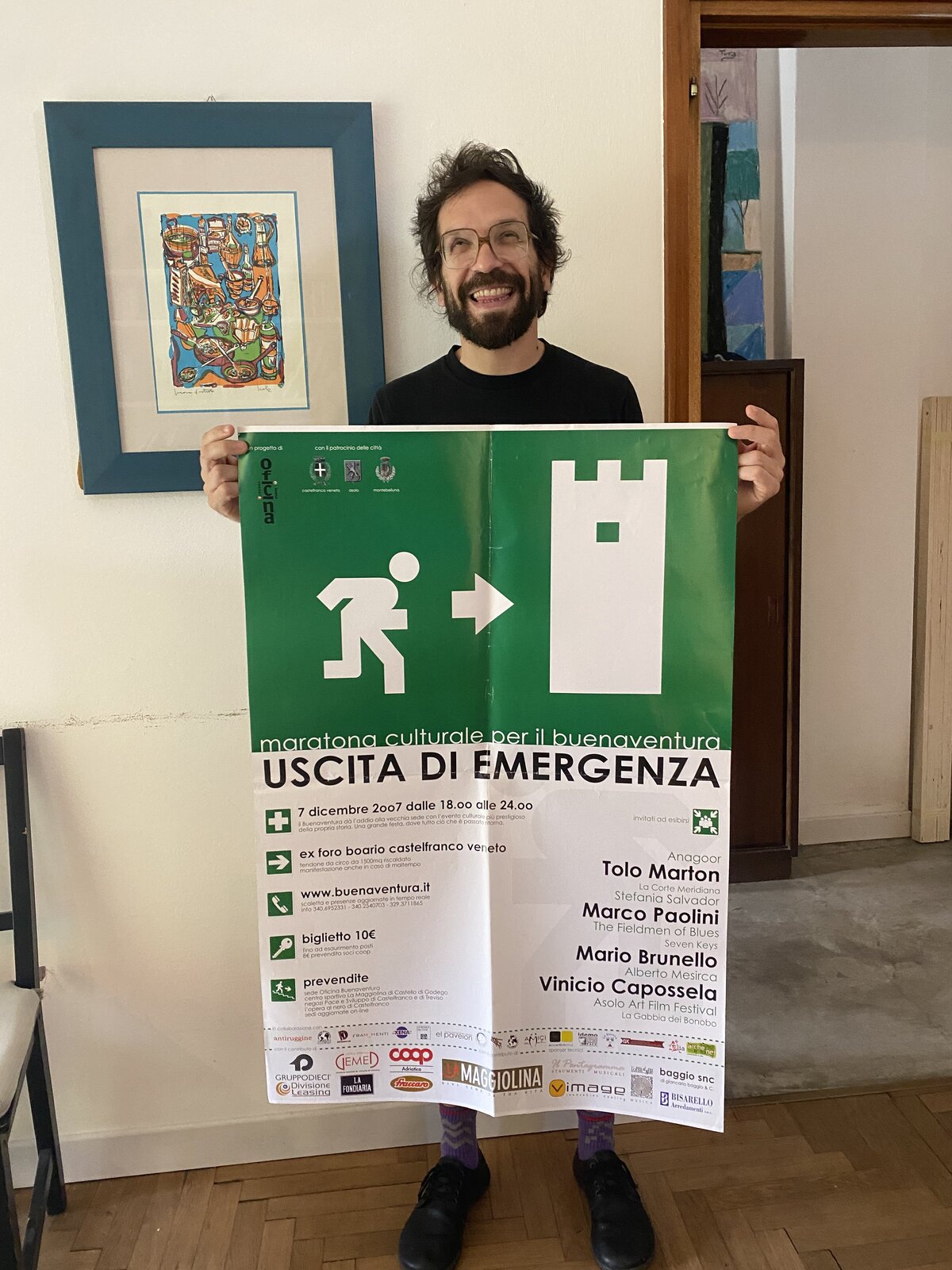 Giulio Favotto con il poster originale di 'Uscita di Emergenza' tra le mani, conservato da Walesa in casa per 18 anni e mezzo e fotografato nel maggio 2026
